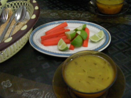 plate of carrots and limes and a bowl of soup