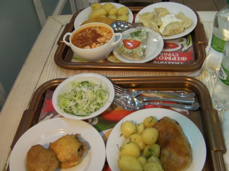 two trays full of plates and bowls of food