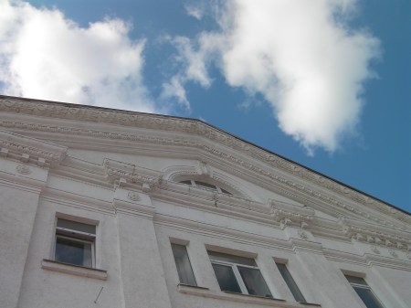 blue sky, white clouds, ornate gable of an old building