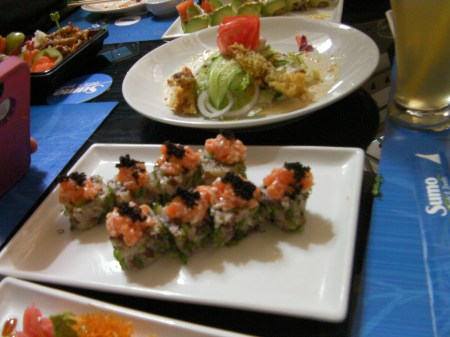sushi roll of brown rice topped with salmon