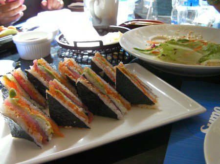 rice, salmon, tuna layered and cut in triangle shapes