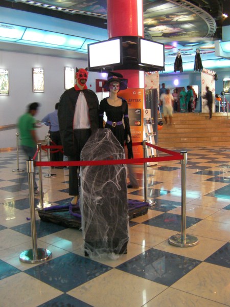a female mannequin dressed as a witch and a male mannequin dressed as a devil with a coffin