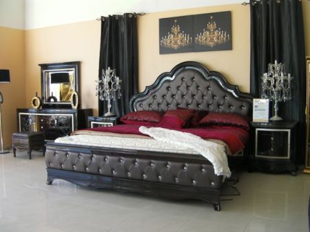 an ornate bed with two candlabras and two pictures of a chandelier