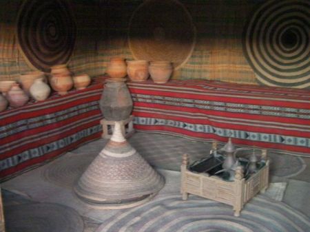 interior of house with coffee pot, clay pots, woven mats