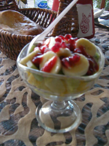 desert bowl with fresh bananas, orange, apple, pomegranate seeds