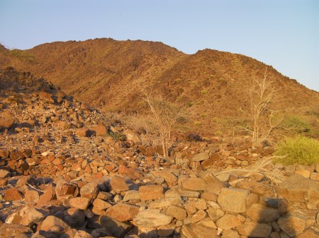 stone house ruins in the foreground, hills in the background