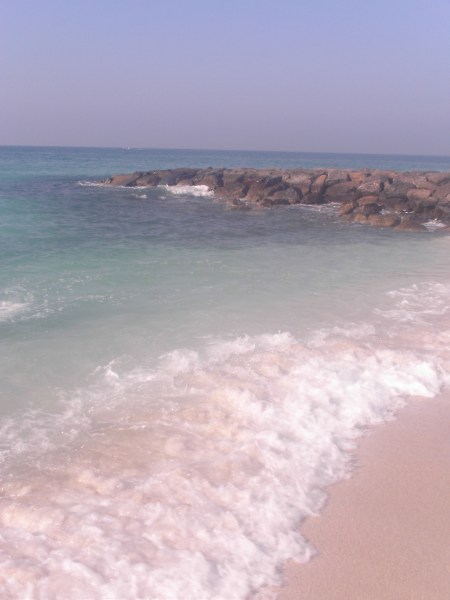 beautiful beach with rocks, sand, and clear water