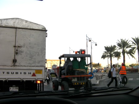landscaping tractor with three men riding on it