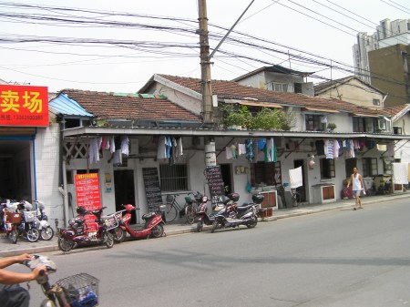 building with scooters parked in front and laundry hanging from the awnings