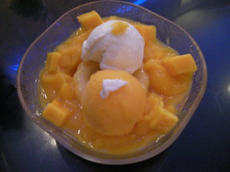 a bowl of mango pudding, chunks, and ice cream