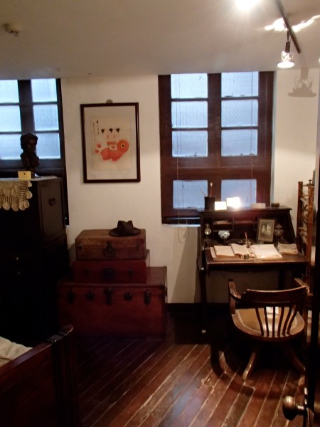 room with small desk and trunks