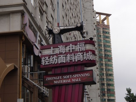 pole sign topped with a sewing machine