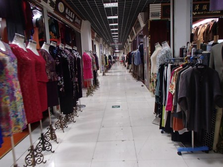 hallway lined with clothing shops but no customers
