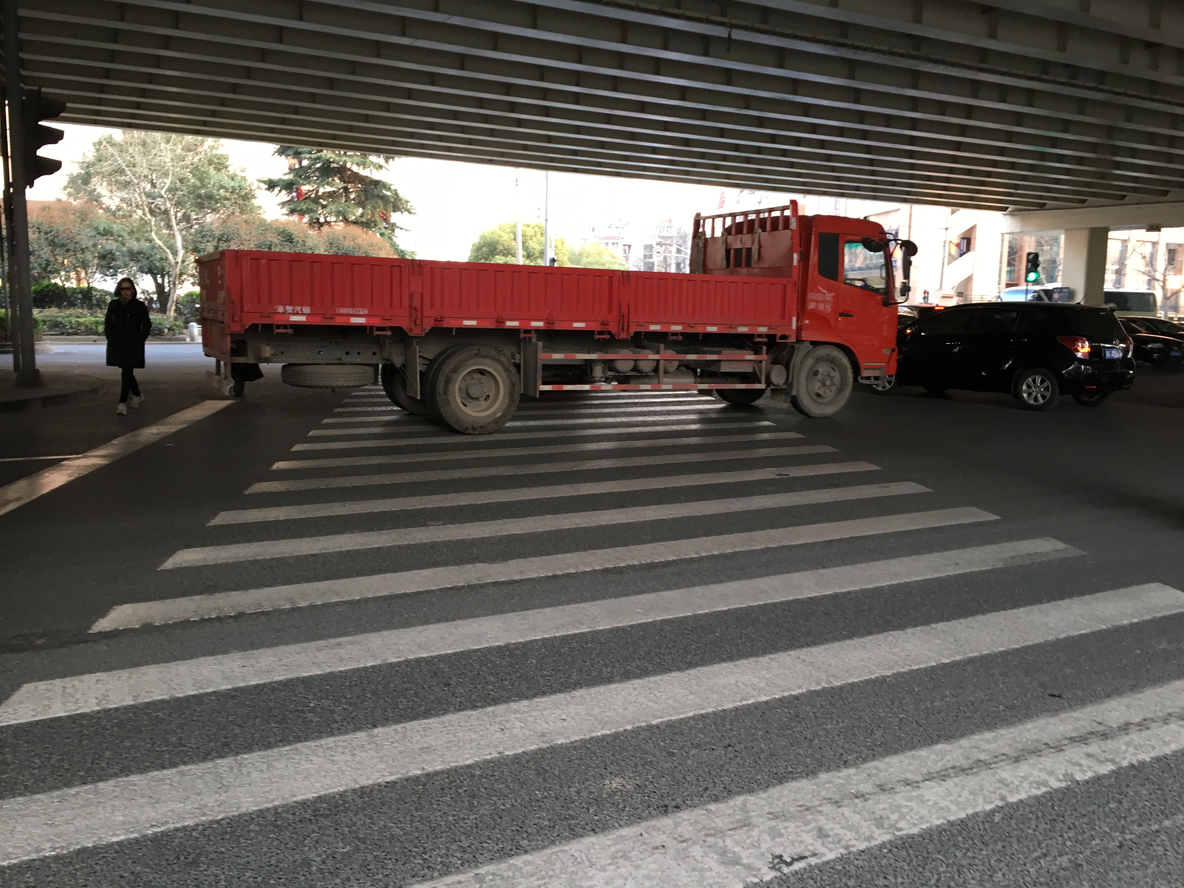 a large red truck blocking a very wide crosswalk