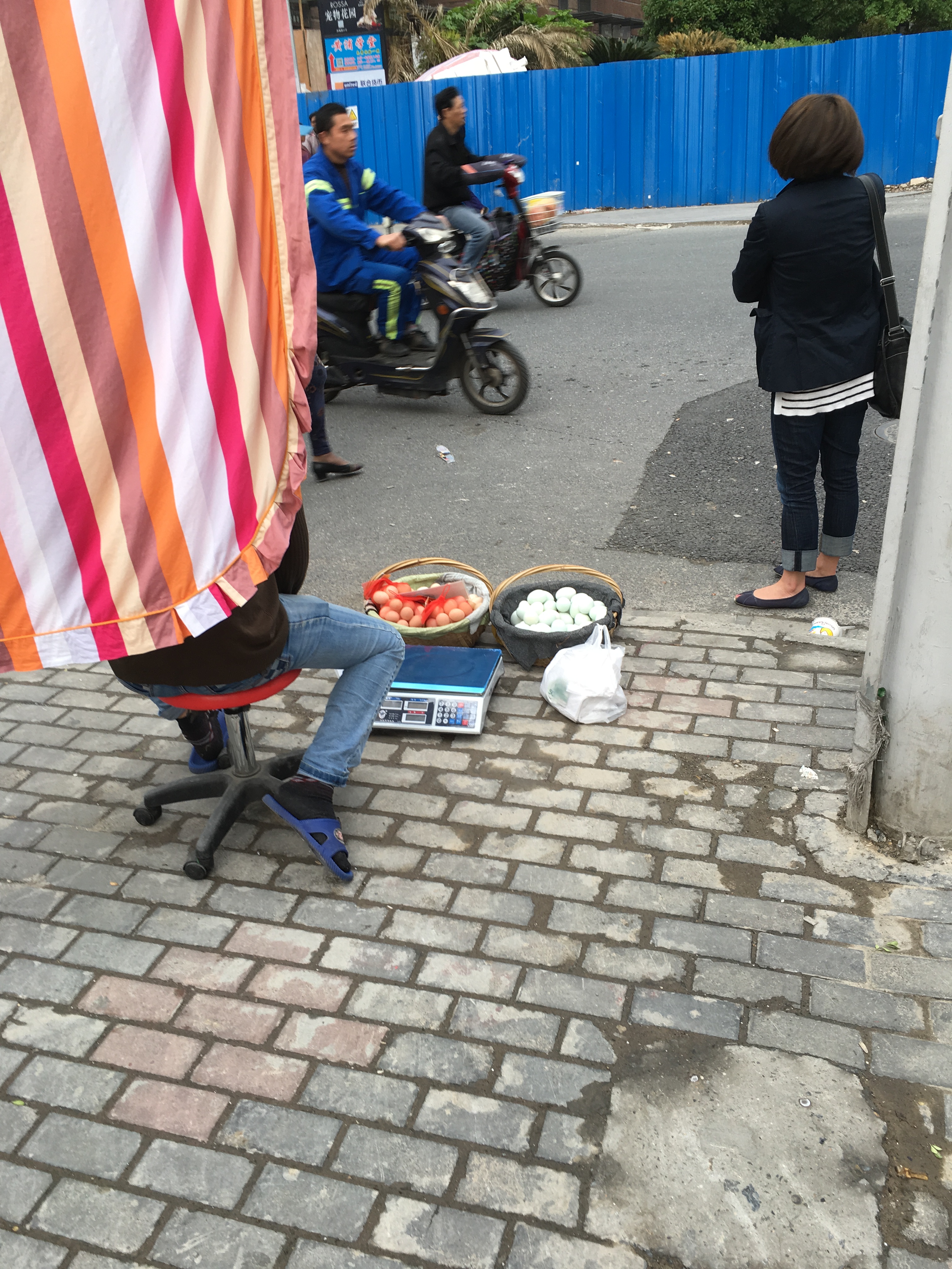 two baskets of eggs and a weighing scale on the sidewalk