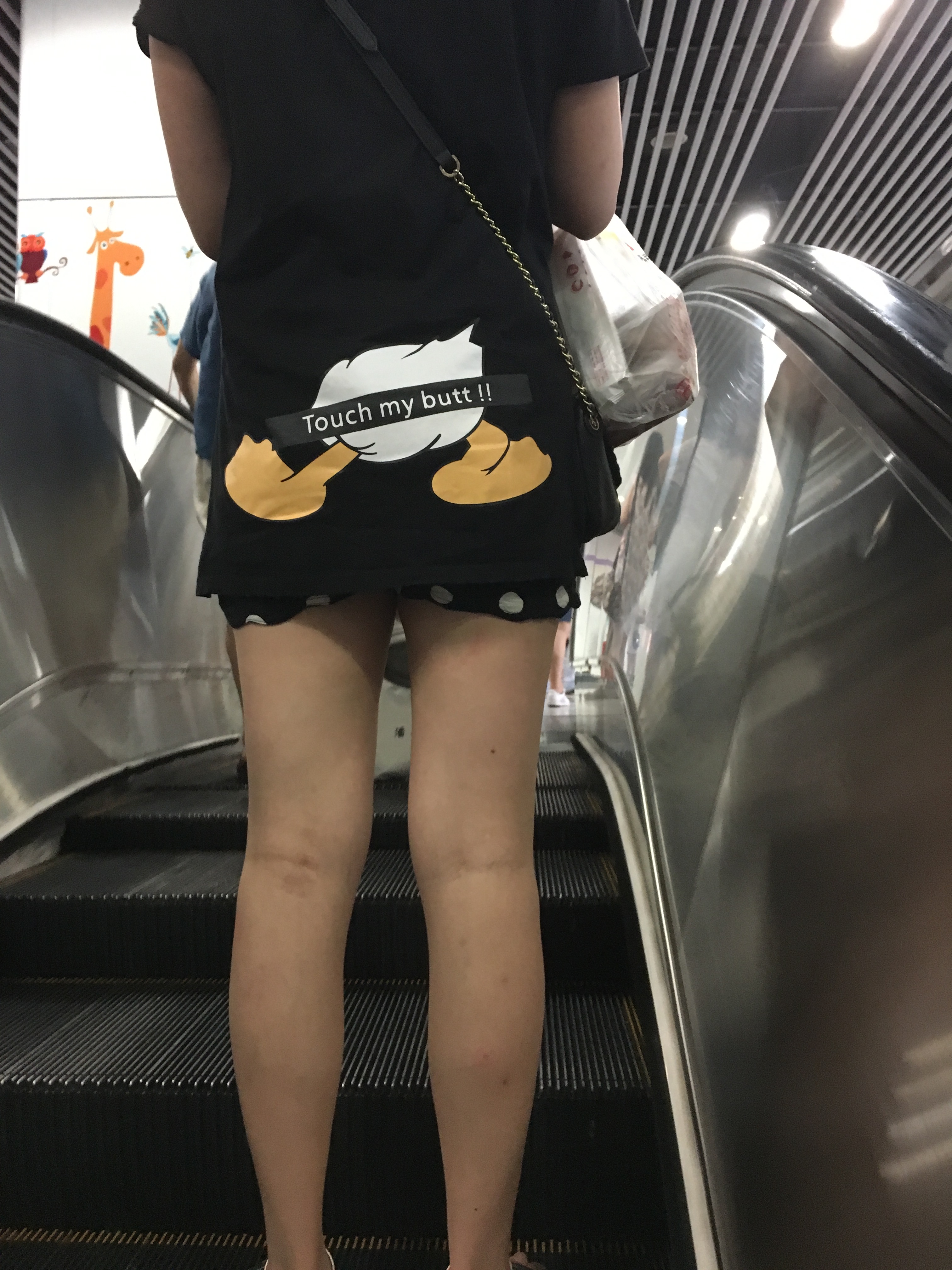 woman wearing a shirt that shows Donald Duck's butt and says 