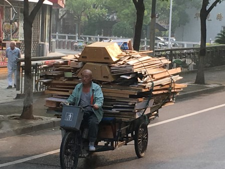 a three wheeled cart full of recycled wood