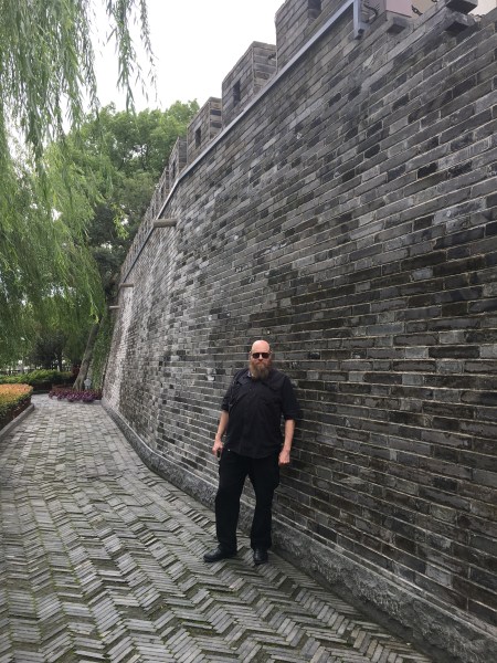 15 foot high grey brick wall with crenellations