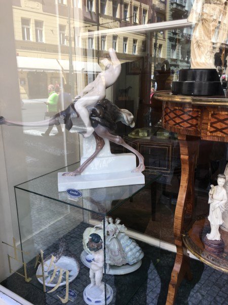 enamel statue of a nude human riding an ostrich
