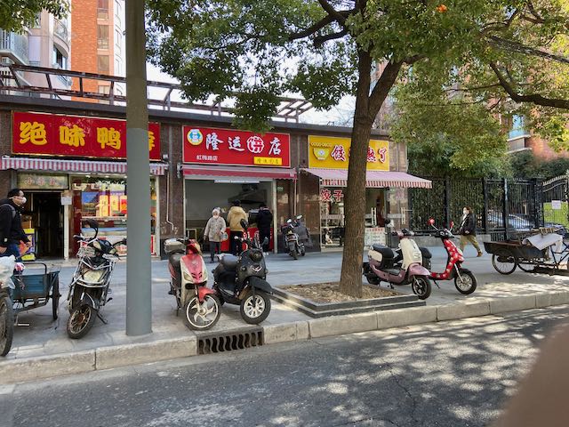 small businesses, sidewalk, people lined up at a food stall