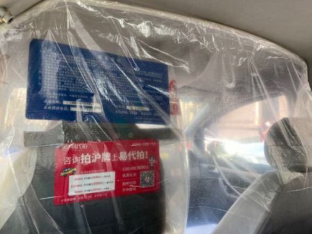 inside of a taxi with plastic sheeting between the driver and passengers