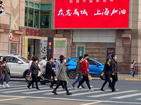 crosswalk where twelve people are crossing all wearing face masks
