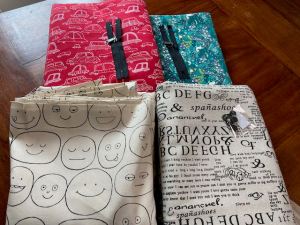 four fabrics including smiley faces, garbled text, cars, and unicorn prints