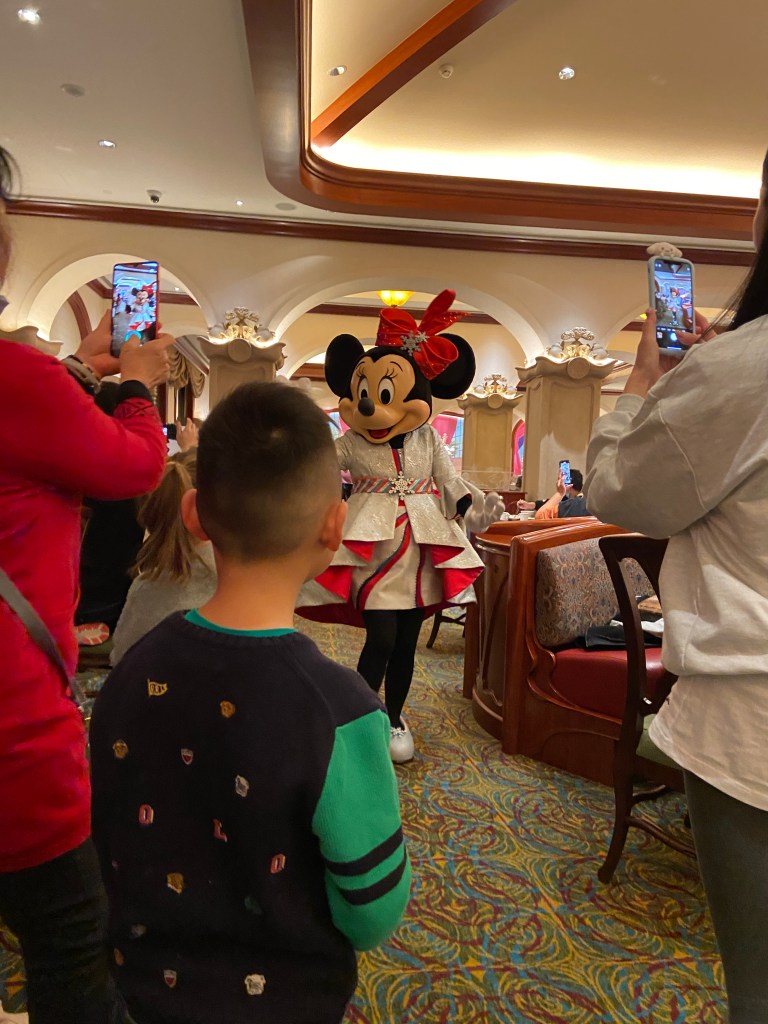 Minnie Mouse being photographed by people in the buffet restaurant