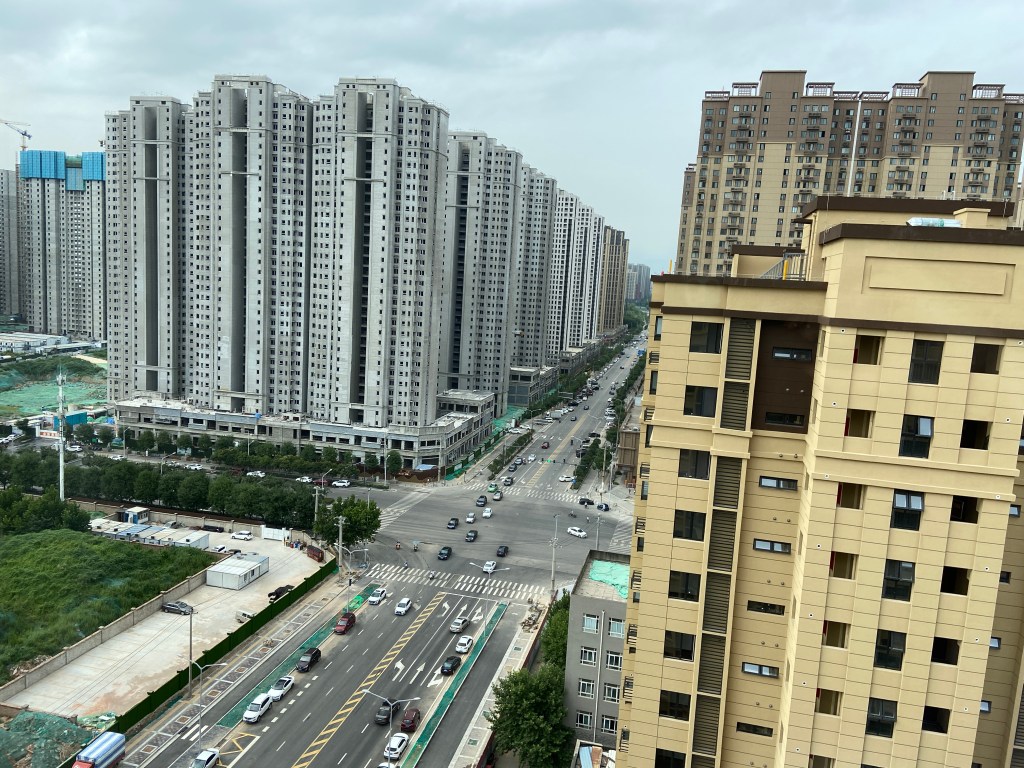 view of tall apartment buildings and a wide street from the 18th floor of a building